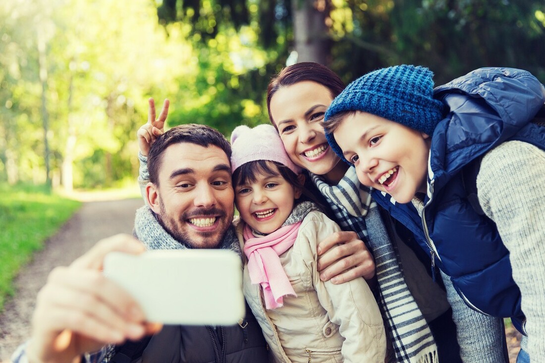 family with backpacks taking selfie by smartphone