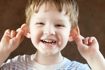 little boy pulling himself on the ears
